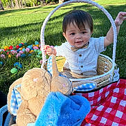 Jayce-Reed Richard joined the competition — help win amazing prizes! child, toddler, basket, easter_eggs, plush_toy, bunny, grass, picnic_blanket, outdoor, sunlight, smiling, clothing, bow_tie, toy, nature, park, happy, sitting, daylight, cute