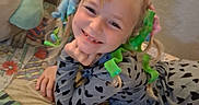 Anastasia joined the competition — help win amazing prizes! child, smiling, bed, colorful_curlers, hair_accessories, patterned_bedspread, pajamas, heart_pattern, lying_down, indoor, happy, cute, face, person, playful, cozy, blond_hair, resting_hand, home, portrait
