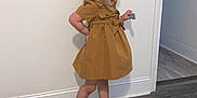 Chloe is registered to the contest to win money with this photo: bodypart, child, clothing, coat, dress, face, female, finger, footwear, girl, hand, hardwood, head, overcoat, person, photography, portrait, sandal, shoe, wood
