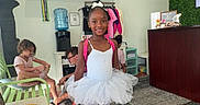 Taisha joined the competition — help win amazing prizes! child, girl, ballerina, tutu, ballet, backpack, smiling, portrait, standing, indoor, waiting_room, wall_art, tree_mural, plants, clothing, pink, white_tights, dance_shoes, carpet, water_cooler