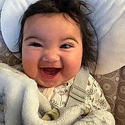 Helena is registered to the contest to win money with this photo: baby, baby_seat, blanket, child, cushion, cute, expression, face, floral, hair, happy, indoor, infant, onesie, portrait, seatbelt, smiling, soft, toddler, wrapped