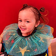Agathe participe au concours pour gagner de l'argent avec cette photo : child, portrait, costume, stars, colorful, tulle, red_background, smile, face, hair, pony_tail, sitting, happy, indoor, playful, cute, fashion, young, person, bright