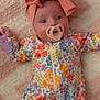 Renesemae Raiyne is registered to the contest to win money with this photo: baby, pacifier, headband, bow, floral_onesie, blanket, infant, cute, child, soft_texture, colorful, portrait, lying_down, happy, small_hands, wide_eyes, comfort, indoors, sleepwear, adorable