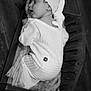 baby, sleeping, knitted_clothing, hat, wooden_cradle, blanket, black_and_white, infant, cozy, cute, peaceful, portrait, indoor, soft_texture, newborn, child, resting, sleep, warm, comfort