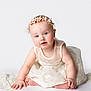 baby, child, infant, dress, white, flower_crown, headband, sitting, cute, portrait, studio, innocence, soft_lighting, rosy_cheeks, hands, feet, looking_at_camera, white_background, smiling, adorable