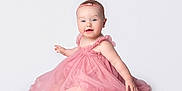Rosanna is registered to the contest to win money with this photo: baby, child, pink_dress, headband, smile, sitting, white_background, cute, infant, portrait, happy, young_child, studio_photo, female, one_person, innocence, soft_fabric, tutu, adorable, barefoot