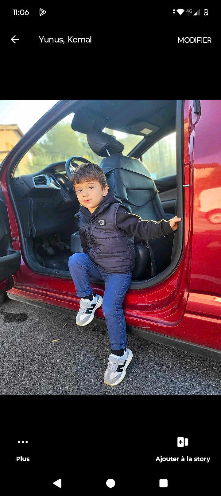 Ilyas a rejoint le concours — aidez-le/la à gagner de superbes lots ! child, boy, car, door, sneakers, clothing, black_vest, blue_pants, outdoor, asphalt, vehicle_interior, seat, curious_expression, casual, daylight, holding_door, young_child, small_person, stepping_out, red_car
