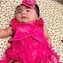 baby, infant, pink_clothing, headband, flower, butterflies, blanket, patterned_blanket, cute, chubby_cheeks, laying_down, soft_lighting, indoor, portrait, child, young_baby, adorable, face, person, resting