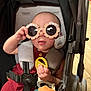 baby, stroller, sunglasses, toy, child, cute, infant, seatbelt, playful, accessory, person, indoor, casual, clothing, hand, face, head, expression, comfort, colorful
