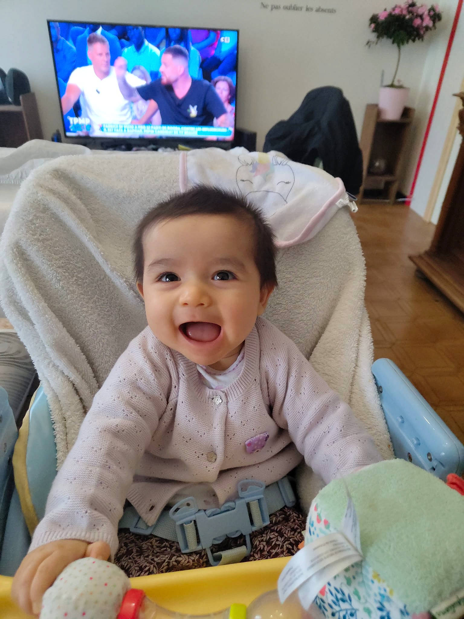 Hanaé participe au concours pour gagner de l'argent avec cette photo : baby, baby_toddler_clothing, beauty, blue, blurred, cable_television, cheek, child, comfort, couch, finger, happy, living_room, output_device, person, plant, room, skin, smile, snapshot