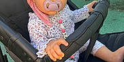 Kahïna participe au concours pour gagner de l'argent avec cette photo : baby, bonnet, cap, clothing, coat, face, furniture, grass, hat, head, jacket, nature, outdoors, park, person, photography, plant, portrait, sitting, stroller