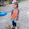 Brylynn Ann Dawn joined the competition — help win amazing prizes! child, girl, playful, orange_shirt, blue_shorts, black_leggings, mismatched_shoes, backpack, headband, outdoor, concrete, trampoline, trees, cloudy, pose, pucker, side_ponytail, casual, yard, nature