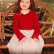 Brylynn Ann Dawn joined the competition — help win amazing prizes! child, girl, smiling, portrait, sitting, wicker_chair, red_sweater, white_skirt, long_hair, indoors, vintage, warm_lighting, soft_focus, furniture, hands, dress, face, person, nostalgic, photograph