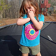 Georgia Deann is registered to the contest to win money with this photo: child, girl, smiling, outdoor, trampoline, backyard, treehouse, forest, woods, daylight, portrait, standing, blue_shirt, donut_shirt, shorts, long_hair, brown_hair, playground, playful, happy