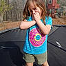child, girl, smiling, outdoor, trampoline, backyard, treehouse, forest, woods, daylight, portrait, standing, blue_shirt, donut_shirt, shorts, long_hair, brown_hair, playground, playful, happy