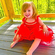 Americus Leighann joined the competition — help win amazing prizes! child, toddler, girl, smiling, portrait, red_dress, outdoor, wooden_deck, forest, sunlight, nature, blonde_hair, blue_eyes, seated, happy, summer, playful, face, person, backyard