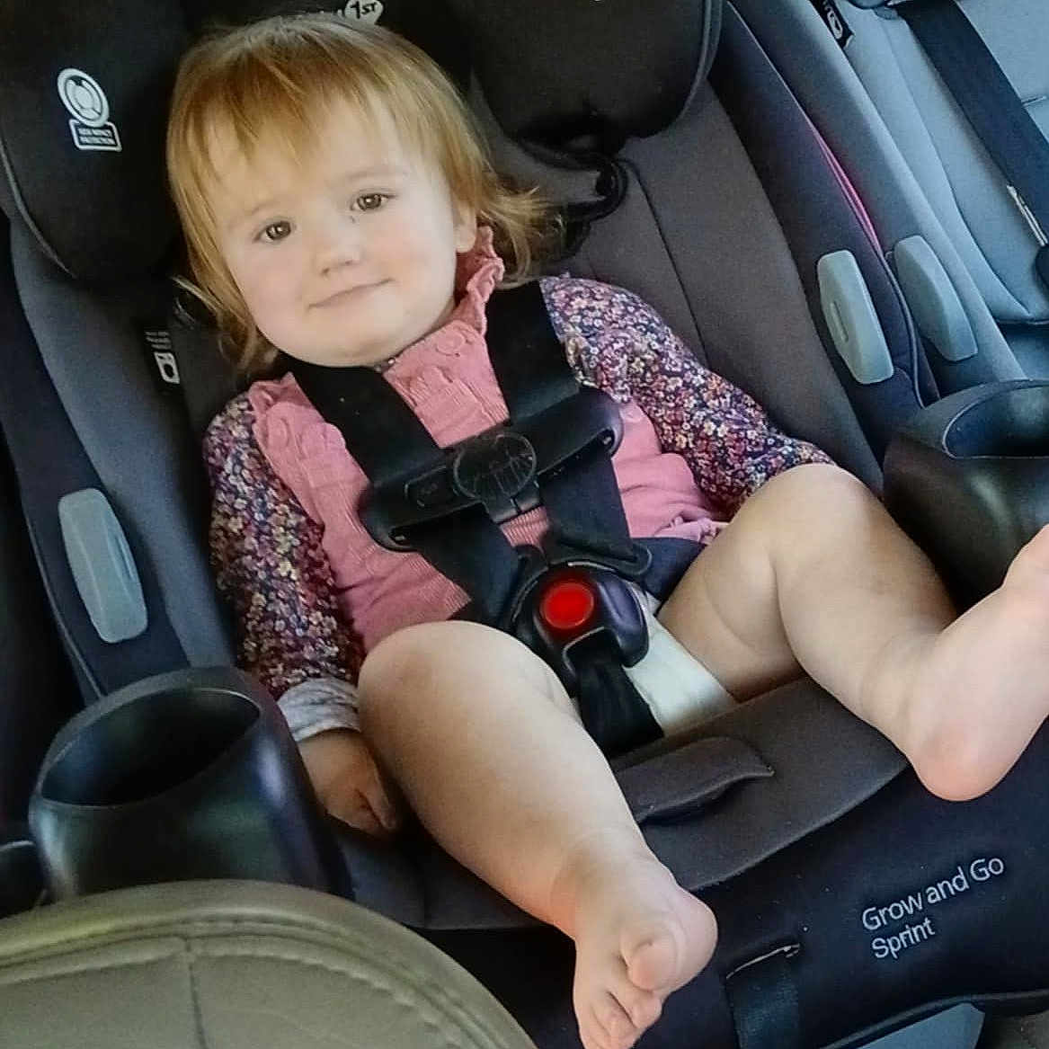 Americus Leighann is registered to the contest to win money with this photo: baby, car_interior, car_seat, child, child_safety, cute, floral_pattern, foot, happy, infant, pink_clothing, portrait, safety_harness, seat, seatbelt, smiling, strapped_in, toddler, travel, young_child