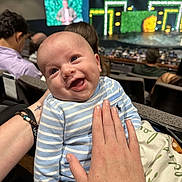 Acen joined the competition — help win amazing prizes! baby, smiling, striped_clothing, blue, infant, hand, auditorium, theater, stage, screen, crowd, seated_people, happy, person, portrait, indoor, blanket, light, event, audience