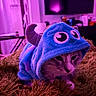 cat, costume, hoodie, monster, purple_light, indoor, rug, pet, cute, animal, feline, cozy, shaggy, playful, soft_toy, face, whiskers, ears, resting, domestic