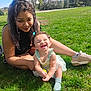 baby, child, woman, grass, outdoor, park, smile, happy, greenery, dress, bow, socks, shoes, tree, basketball_hoop, sunlight, nature, person, laughing, casual