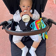 Lazimi joined the competition — help win amazing prizes! baby, beverage, bodypart, clothing, drinking, eating, face, finger, food, footwear, hand, head, hosiery, milk, person, photography, portrait, sitting, sock, stroller