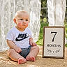 baby, infant, child, blue_eyes, nike_tshirt, shorts, sitting, outdoor, grass, sign, 7_months, lace_curtain, wooden_frame, mat, cute, portrait, sunlight, natural_light, expression, young