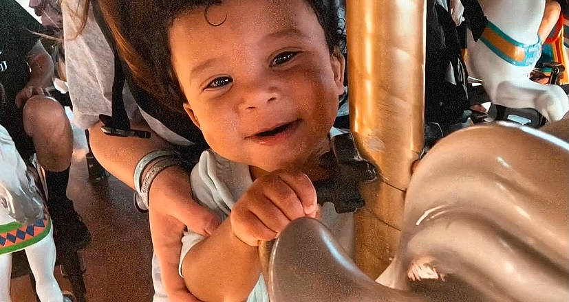 Kellen is registered to the contest to win money with this photo: cheek, child, close_up, eyelash, facial_expression, finger, fun, gesture, happy, human, mammal, mouth, nose, organ, person, skin, smile, thumb, toddler, tree