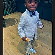 Keyphren participe au concours pour gagner de l'argent avec cette photo : toddler, child, boy, indoor, wooden_floor, white_shirt, bow_tie, sneakers, pants, standing, holding, container, cute, portrait, person, shoes, looking, expression, fashion, casual