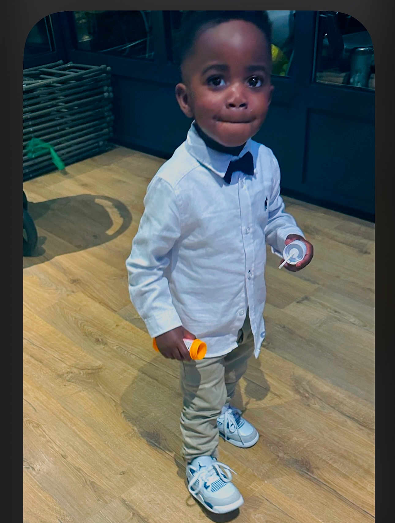 Keyphren participe au concours pour gagner de l'argent avec cette photo : toddler, child, boy, indoor, wooden_floor, white_shirt, bow_tie, sneakers, pants, standing, holding, container, cute, portrait, person, shoes, looking, expression, fashion, casual