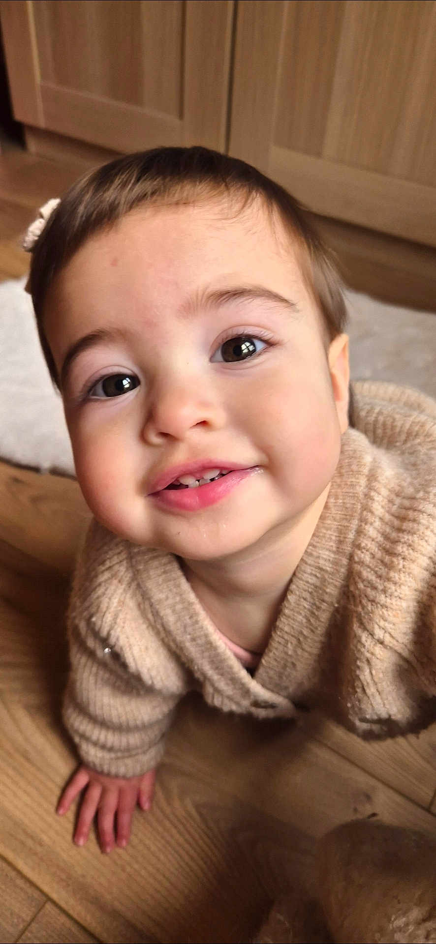 Mathilde a rejoint le concours — aidez-le/la à gagner de superbes lots ! child, toddler, baby, face, smile, teeth, eyes, cheeks, hand, sweater, knitwear, indoor, wood_floor, crawling, portrait, closeup, hair, cabinet, cozy, adorable