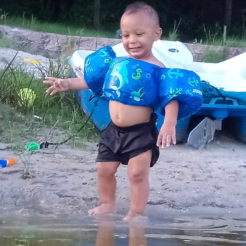 Zhyion Grant joined the competition — help win amazing prizes! adult, back, boy, child, clothing, face, head, lifejacket, male, man, nature, outdoors, person, photography, pond, portrait, puddle, shorts, vest, water