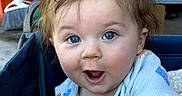 Leonard joined the competition — help win amazing prizes! baby, child, blue_eyes, plush_toy, stroller, clothing, happy, smiling, indoor, furniture, person, cute, infant, toy, hand, face, hair, expression, bicycle, background