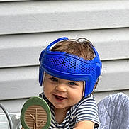 Leonard joined the competition — help win amazing prizes! baby, child, helmet, blue_helmet, smile, happy, toy, tree_toy, high_chair, striped_shirt, indoor, person, face, cute, playful, young_child, infant, headgear, sitting, background