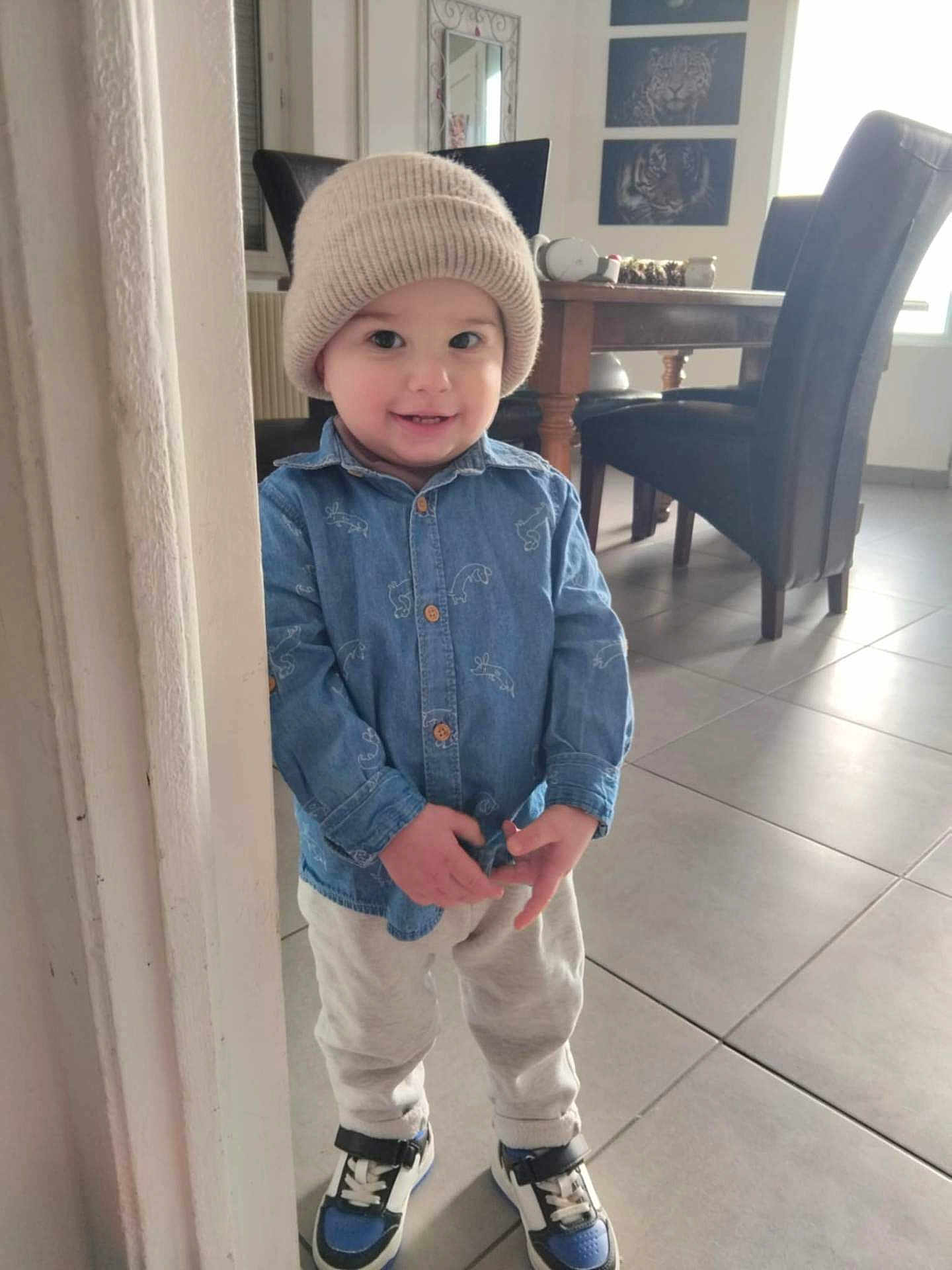 Maylone a rejoint le concours — aidez-le/la à gagner de superbes lots ! casual_clothing, chairs, child, cozy, cute, denim_shirt, dining_table, floor_tiles, happy, hat, home, indoor, person, portrait, smile, sneakers, standing, toddler, wall_art, young_child