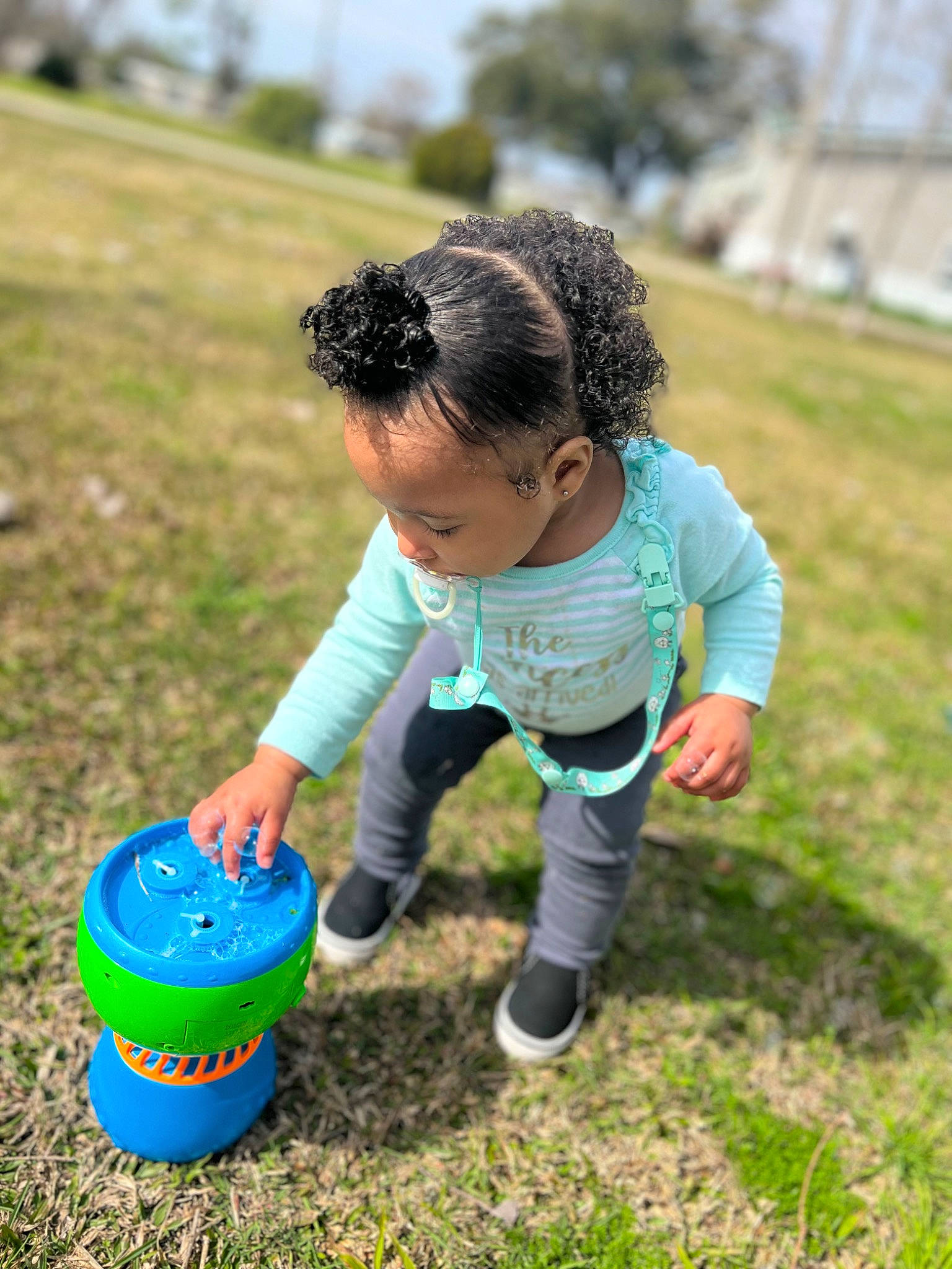 Tahani is registered to the contest to win money with this photo: baby, baby_toddler_clothing, ball, bucket, child, fun, grass, grassland, happy, lawn, leisure, people_in_nature, person, plant, play, recreation, sky, sneakers, soil, toddler