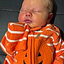 Tucker joined the competition — help win amazing prizes! baby, sleeping, infant, orange_clothing, striped_clothing, jack_o_lantern, cute, portrait, child, cozy, resting, face, head, young_child, soft_lighting, indoors, cushion, black_background, zipper, holiday_clothing