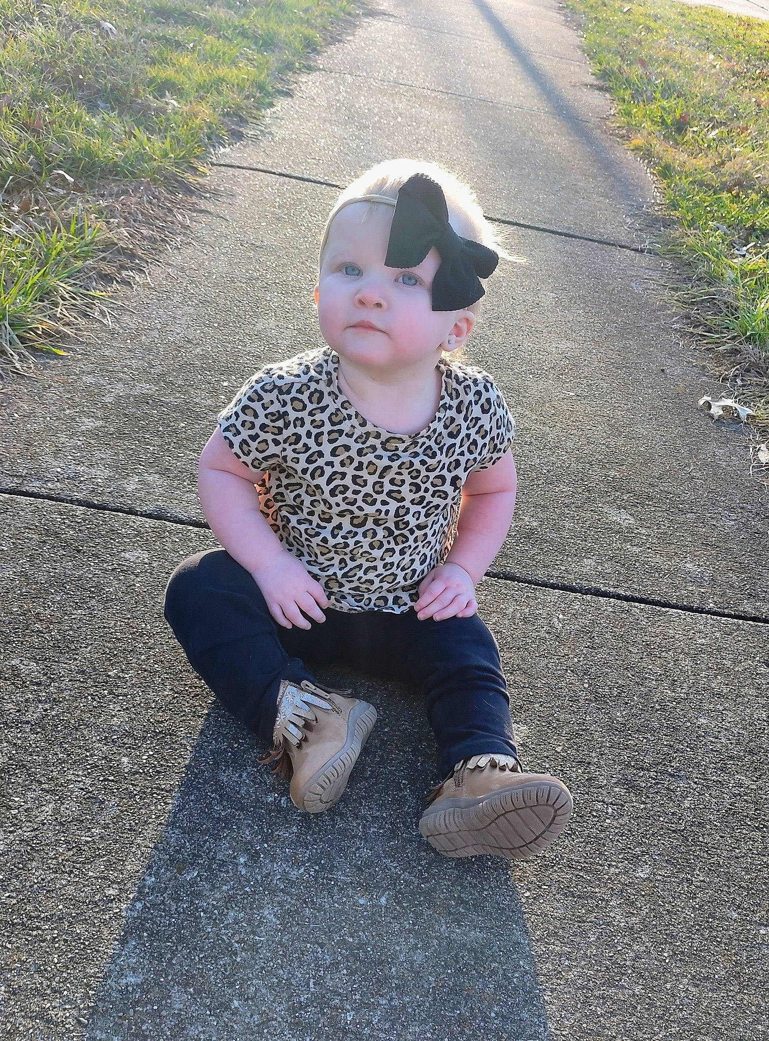 Everly is registered to the contest to win money with this photo: asphalt, baby, baby_toddler_clothing, child, fun, grass, grass_family, happy, human_body, lawn, pattern, people_in_nature, person, plant, recreation, road_surface, sitting, sleeve, t_shirt, tar