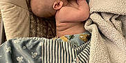 Bryson joined the competition — help win amazing prizes! baby, sleeping, blanket, baby_seat, carpet, foot, water_bottle, indoor, soft_texture, pattern, child, infant, rest, comfort, napping, person, head, skin, clothing, home