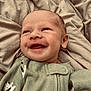 Bryson is registered to the contest to win money with this photo: baby, smiling, infant, pajamas, green_clothing, blanket, bed, face, happy, cute, newborn, skin, lying_down, cozy, child, expression, indoors, person, sleepwear, soft