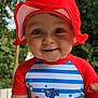 baby, child, red_hat, swimsuit, striped_clothing, outdoor, smile, face, cute, sun_hat, cartoon_print, baby_clothing, greenery, summer, portrait, happy, headwear, infant, nature, daylight