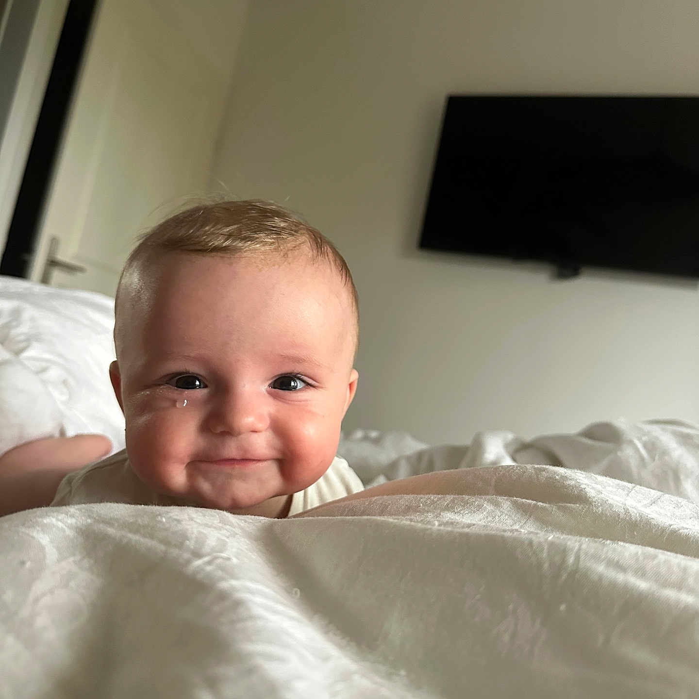 Andrew participe au concours pour gagner de l'argent avec cette photo : baby, smiling, tear, bed, white_bedspread, indoor, face, head, person, child, room, door, television, modern, happy, infant, portrait, candid, cute, soft_light
