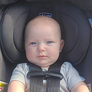 Kenneth is registered to the contest to win money with this photo: baby, child, car_seat, blue_eyes, face, infant, seatbelt, safety_harness, clothing, cute, portrait, young_child, head, skin, person, young, indoors, seat, straps, expression