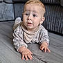 Henry joined the competition — help win amazing prizes! baby, infant, child, floor, wooden_floor, couch, sofa, furniture, dinosaur_pattern, clothing, bib, hands, face, eyes, curious, indoor, home, cute, portrait, person