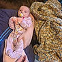 Sylvia joined the competition — help win amazing prizes! baby, infant, pacifier, plush_toy, striped_pajamas, adult_hand, blanket, couch, knitted_blanket, comfort, cozy, indoor, person, holding, sleepwear, resting, cute, soft_texture, warm, family
