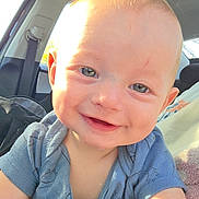 Lawson is registered to the contest to win money with this photo: baby, infant, child, smiling, close_up, face, blue_onesie, drooling, cheeks, blond_hair, car_interior, car_seat, seatbelt, window, sunlight, portrait, happy, eyes, ear, hand