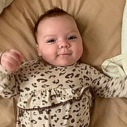 Gianna joined the competition — help win amazing prizes! baby, infant, bed, blanket, leopard_print, clothing, cute, face, smile, lying_down, child, young, person, sleepwear, bedroom, soft, happy, skin, head, pajamas