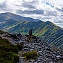 adventure, animal, canine, clouds, daylight, dog, greenery, hill, landscape, majestic, mountain, nature, outdoor, rocks, rocky_path, scenic, serene, sky, trail, wilderness
