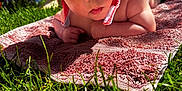 Theo is registered to the contest to win money with this photo: baby, infant, hat, sun_hat, towel, grass, outdoor, child, cute, portrait, skin, hand, summer, daylight, nature, closeup, laying_down, wide_eyes, curious, baby_skin