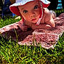 baby, infant, hat, sun_hat, towel, grass, outdoor, child, cute, portrait, skin, hand, summer, daylight, nature, closeup, laying_down, wide_eyes, curious, baby_skin
