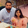 child, girl, father, adult, portrait, smiling, indoor, party, celebration, pink_dress, formal_clothing, long_hair, table, dessert, cake, fruit, tea_set, flowers, decorations, family